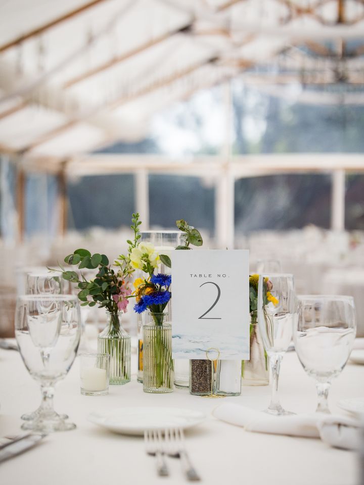 Bud vases and floating candles create the centerpiece on this wedding guest reception table.