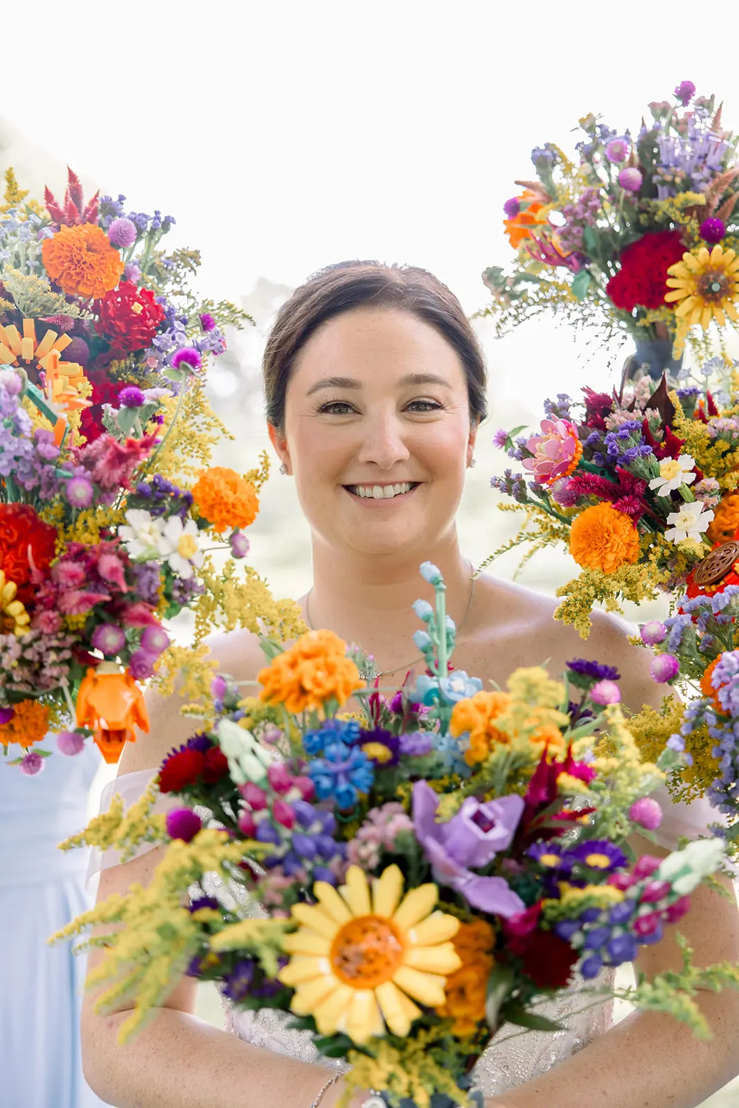 Bride smiles in the center , while bridesmaids hold their LEGO Flowers bouquets around her in a frame.