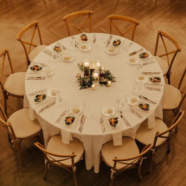 Greenery on a round table for an indoor winter wedding by Wildly Native Flower Farm