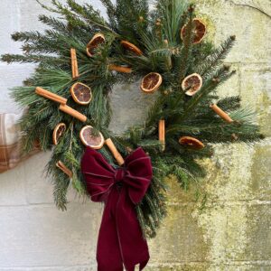 Christmas wreath with dried cinnamon sticks and orange slices.