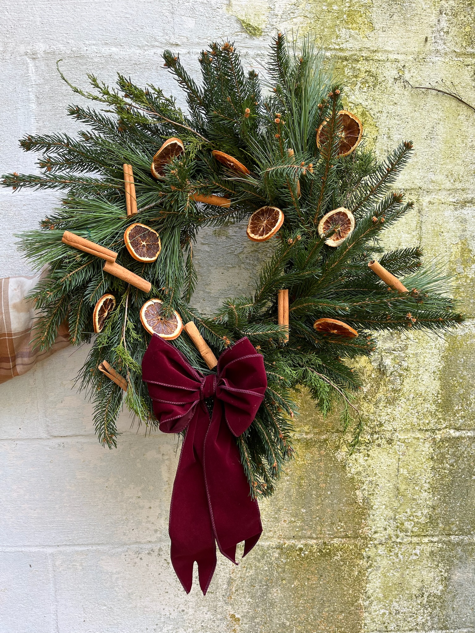 Christmas wreath with dried cinnamon sticks and orange slices.